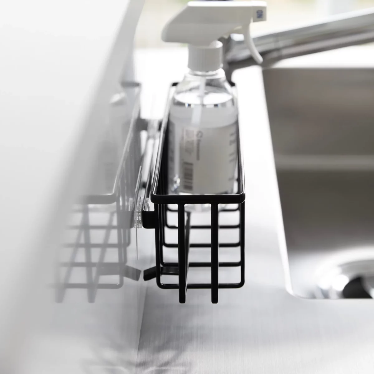 Yamazaki TOWER Film Hook multi-use basket L in black, close-up from the side with a spray bottle