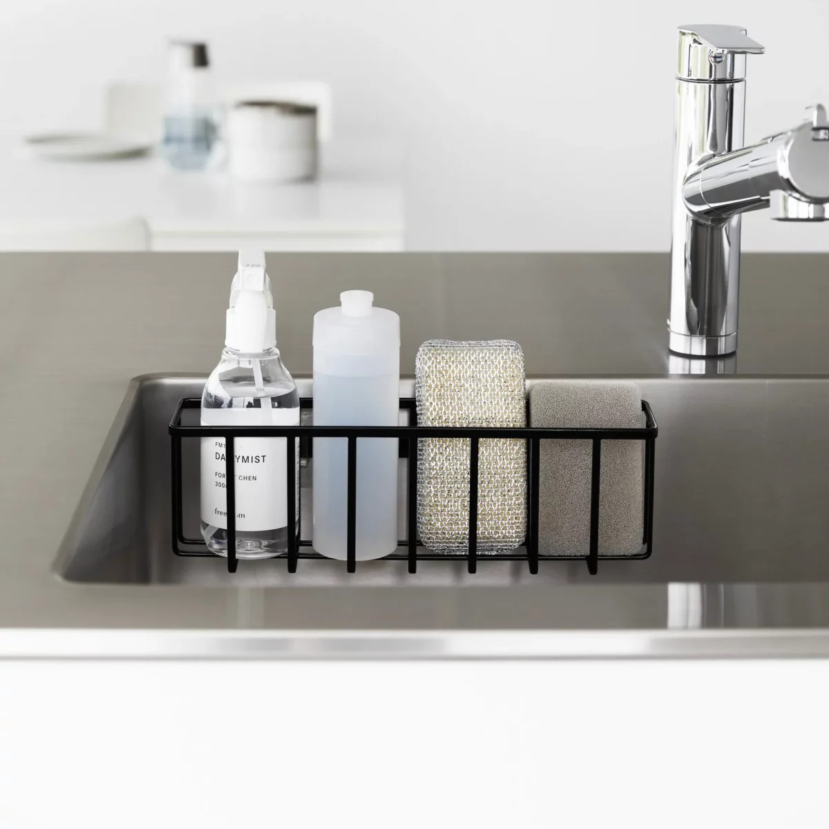 Yamazaki TOWER Film Hook multi-use basket L in black, front view in the sink with bottles and a sponge