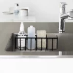 Yamazaki TOWER Film Hook multi-use basket L in black, front view in the sink with bottles and a sponge