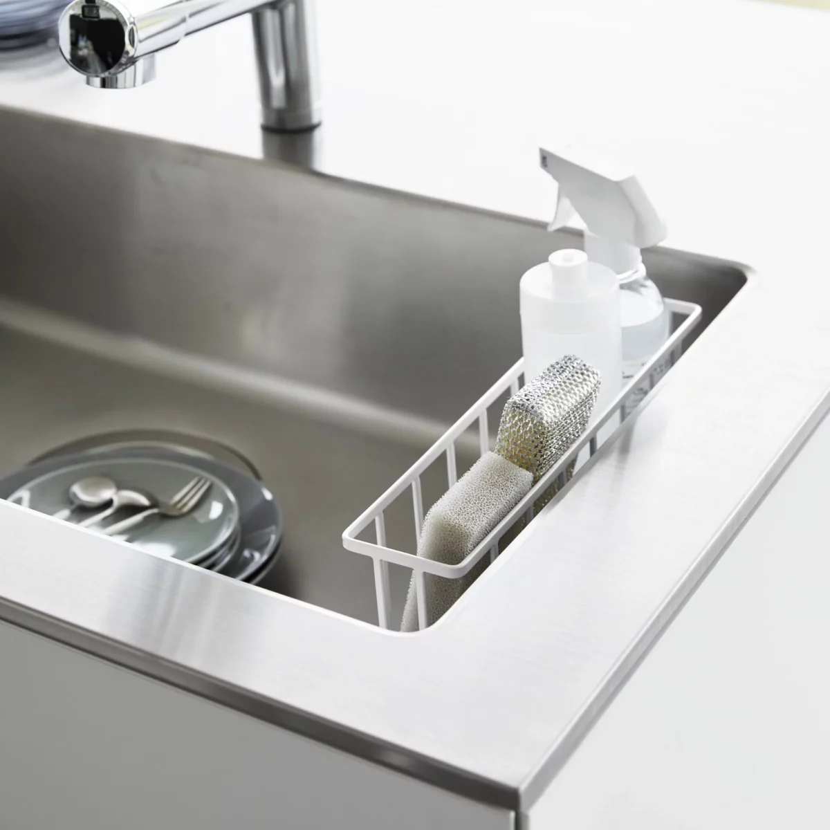 Yamazaki TOWER Film Hook multi-use basket L in white, top view inside the sink with bottles and a sponge