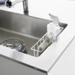 Yamazaki TOWER Film Hook multi-use basket L in white, top view inside the sink with bottles and a sponge