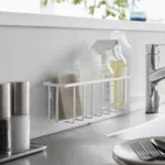 Yamazaki TOWER Film Hook multi-use basket L in white, on the back wall of the sink with bottles and a sponge