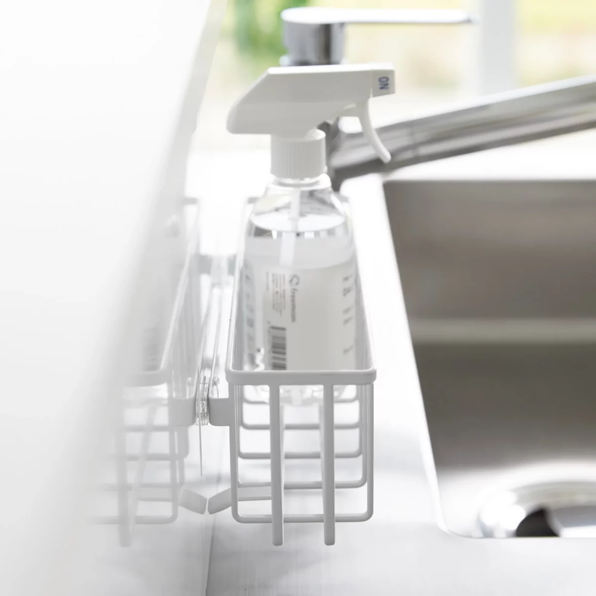 Yamazaki TOWER Film Hook multi-use basket L in white, close-up from the side with a spray bottle
