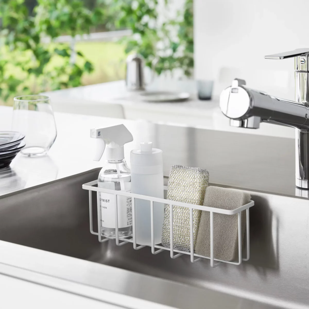 Yamazaki TOWER Film Hook multi-use basket L in white, inside the sink wall with dish soap and a sponge