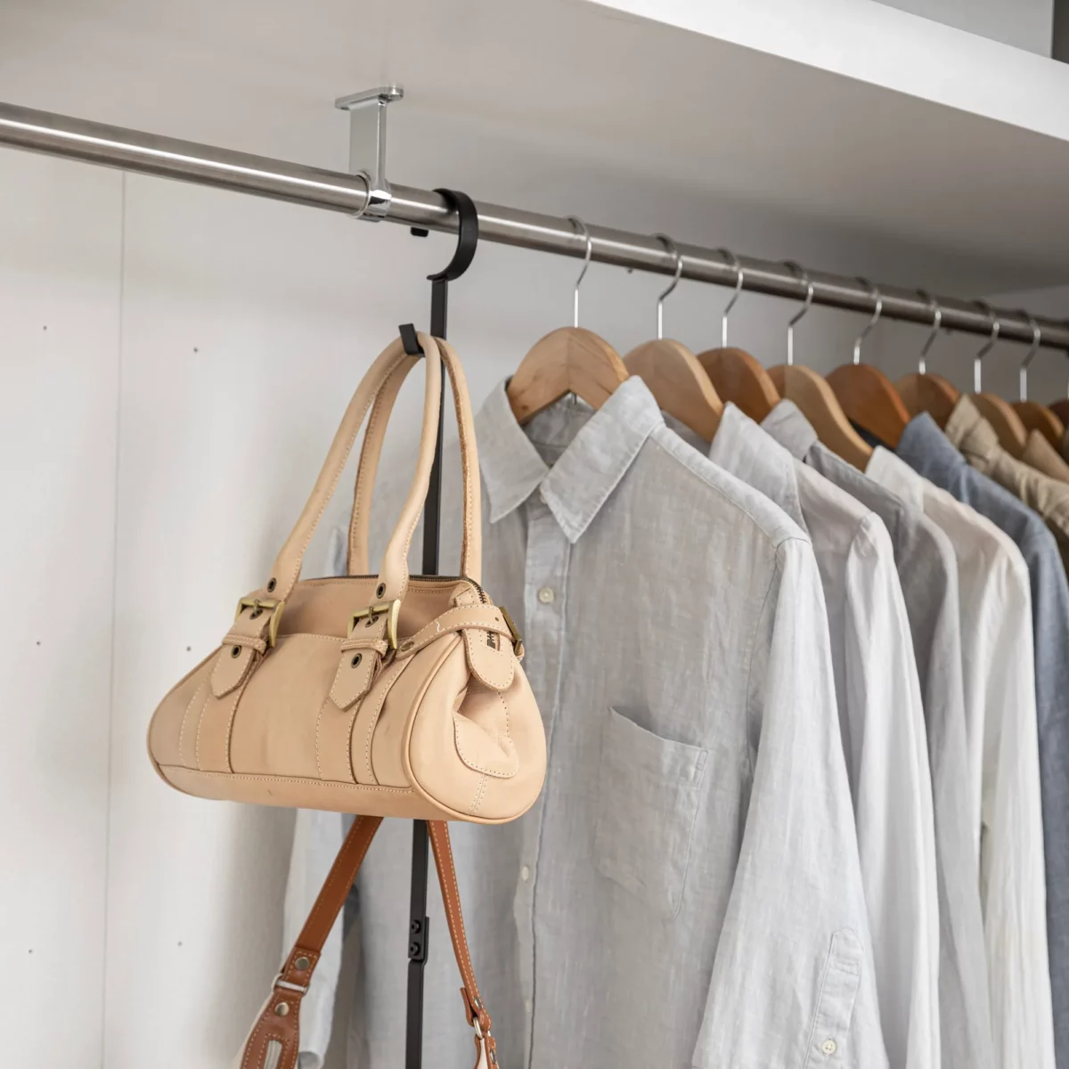 Yamazaki SMART 2-Tier Extendable Clothes Rod in Black; a handbag is hanging from the hook on the side