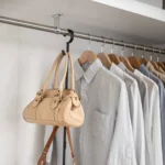 Yamazaki SMART 2-Tier Extendable Clothes Rod in Black; a handbag is hanging from the hook on the side
