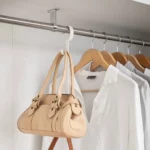 Yamazaki SMART 2-tier extendable clothes rod in white; a handbag is hanging from the hook on the side