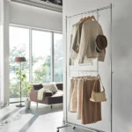Yamazaki SMART 2-tier extendable clothes rod in white, hung on an open clothes rack in the living room