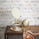 Yamazaki TOSCA makeup mirror with shelves in white, on the wooden table in front of a white brick wall
