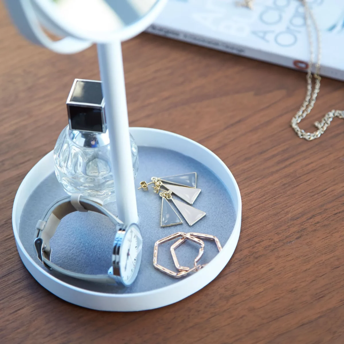 Miroir de maquillage Yamazaki TOWER avec tablette, couleur blanche ; gros plan sur la tablette en feutre avec une montre et des boucles d'oreilles