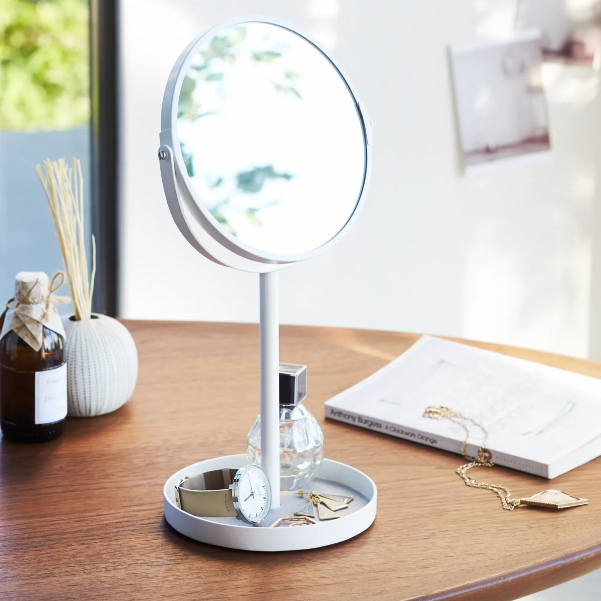 Miroir de maquillage Yamazaki TOWER avec tablette, couleur blanche, posé sur une table en bois avec un parfum, une montre et des bijoux