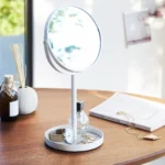 Miroir de maquillage Yamazaki TOWER avec tablette, couleur blanche, posé sur une table en bois avec un parfum, une montre et des bijoux