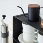 Yamazaki Küchenregal TOWER schmal stapelbar in Schwarz, Nahaufnahme mit Kanne und Nüssen über den Tassen