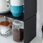 Yamazaki Küchenregal TOWER schmal stapelbar in Schwarz, Nahaufnahme mit Tassen über dem Kaffeeglas