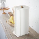 Yamazaki Küchenrollenhalter TOSCA in Weiss, schräg von vorne auf der Holzablage mit voller Rolle