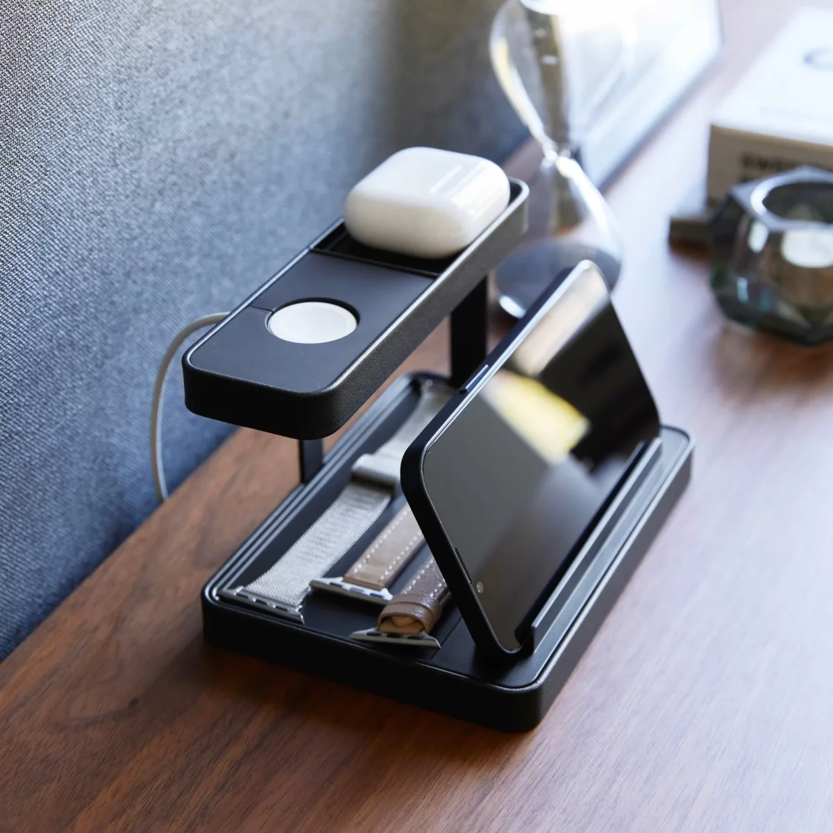 Yamazaki Ladeständer TOWER für Smartphone und Uhr in Schwarz, schräg mit Smartphone vorne und Kopfhörern oben