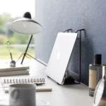 Support 2 en 1 TOWER pour ordinateur et tablette Yamazaki coloris noir, debout contre le mur avec ordinateur rangé verticalement