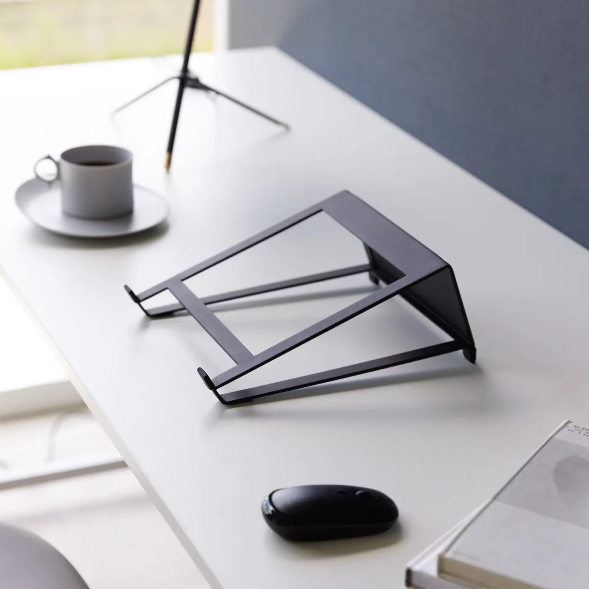 Support 2 en 1 TOWER pour ordinateur et tablette Yamazaki coloris noir, vide sur le bureau près d’une tasse et d’une souris