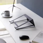 Support 2 en 1 TOWER pour ordinateur et tablette Yamazaki coloris noir, vide sur le bureau près d’une tasse et d’une souris