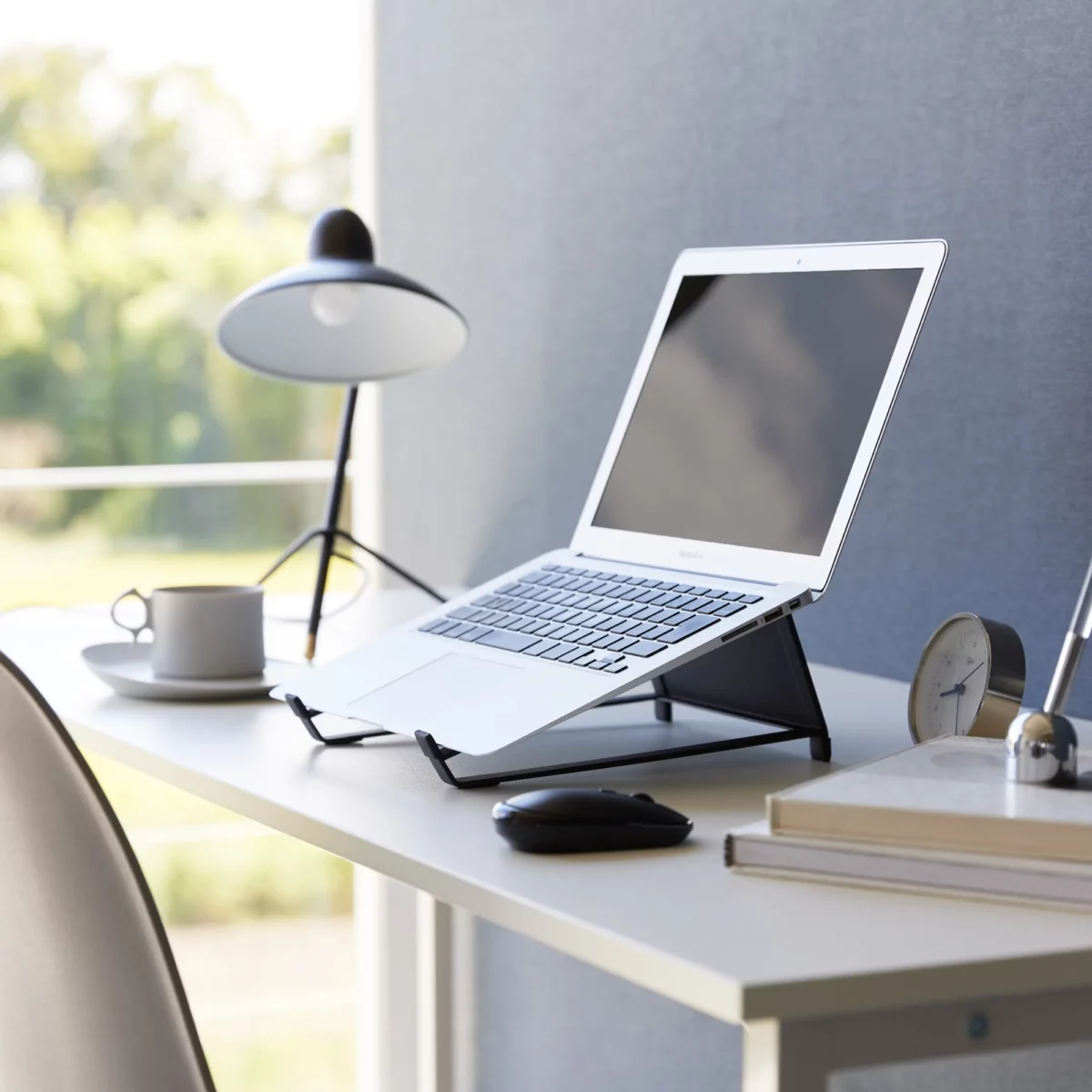 Support 2 en 1 TOWER pour ordinateur et tablette Yamazaki coloris noir, sur un bureau avec ordinateur ouvert près d’une fenêtre