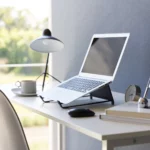 Support 2 en 1 TOWER pour ordinateur et tablette Yamazaki coloris noir, sur un bureau avec ordinateur ouvert près d’une fenêtre