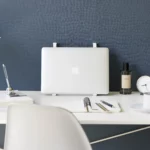 Support 2 en 1 TOWER pour ordinateur et tablette Yamazaki coloris blanc, debout de face avec ordinateur devant un mur bleu