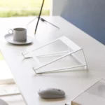 Support 2 en 1 TOWER pour ordinateur et tablette Yamazaki coloris blanc, vide sur le bureau près d’une tasse et d’une souris
