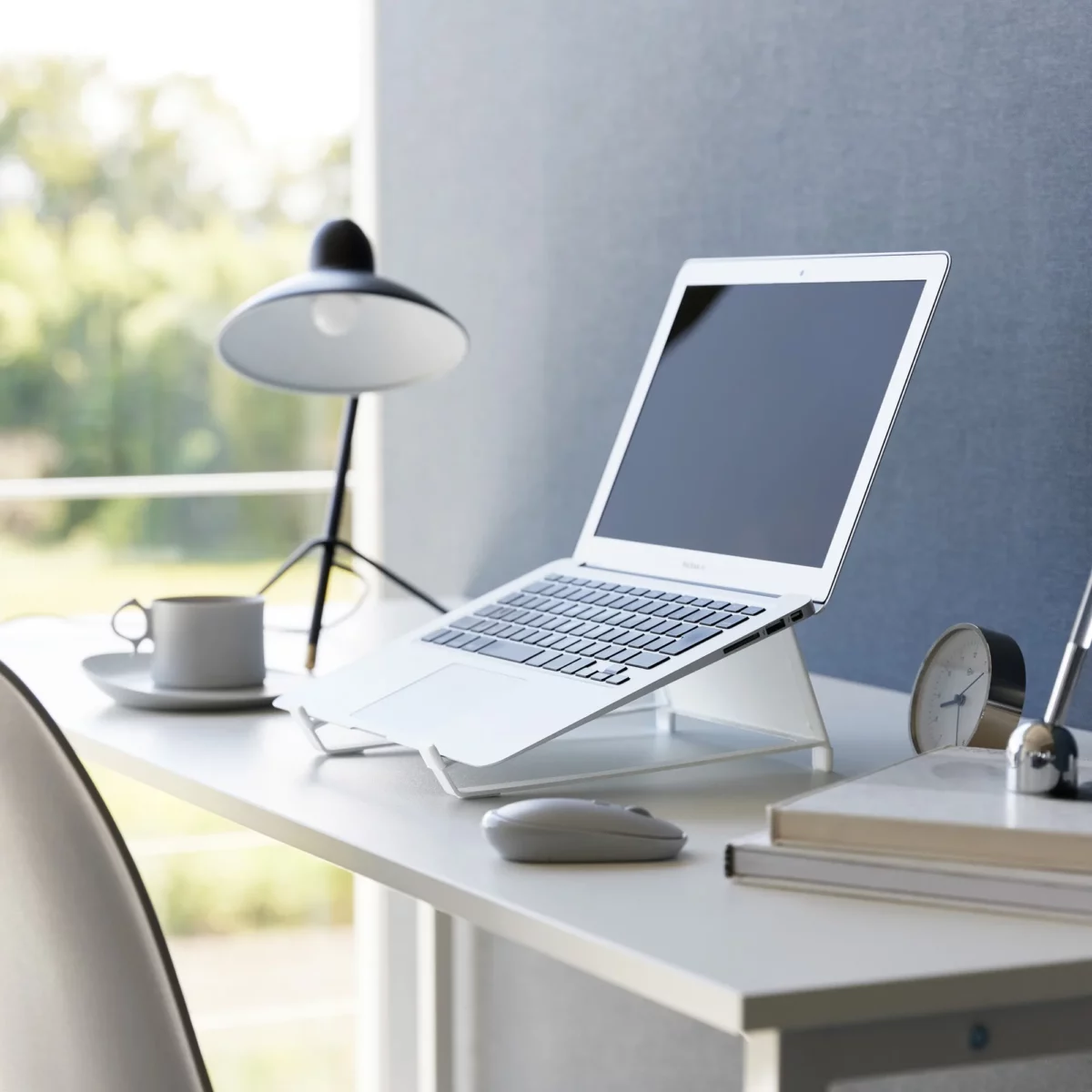 Support 2 en 1 TOWER pour ordinateur et tablette Yamazaki coloris blanc, sur un bureau avec ordinateur ouvert près d’une fenêtre