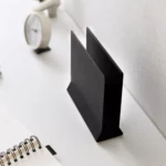 Support pour ordinateur portable Yamazaki TOWER vertical, noir, posé à vide sur le bureau à côté du cahier