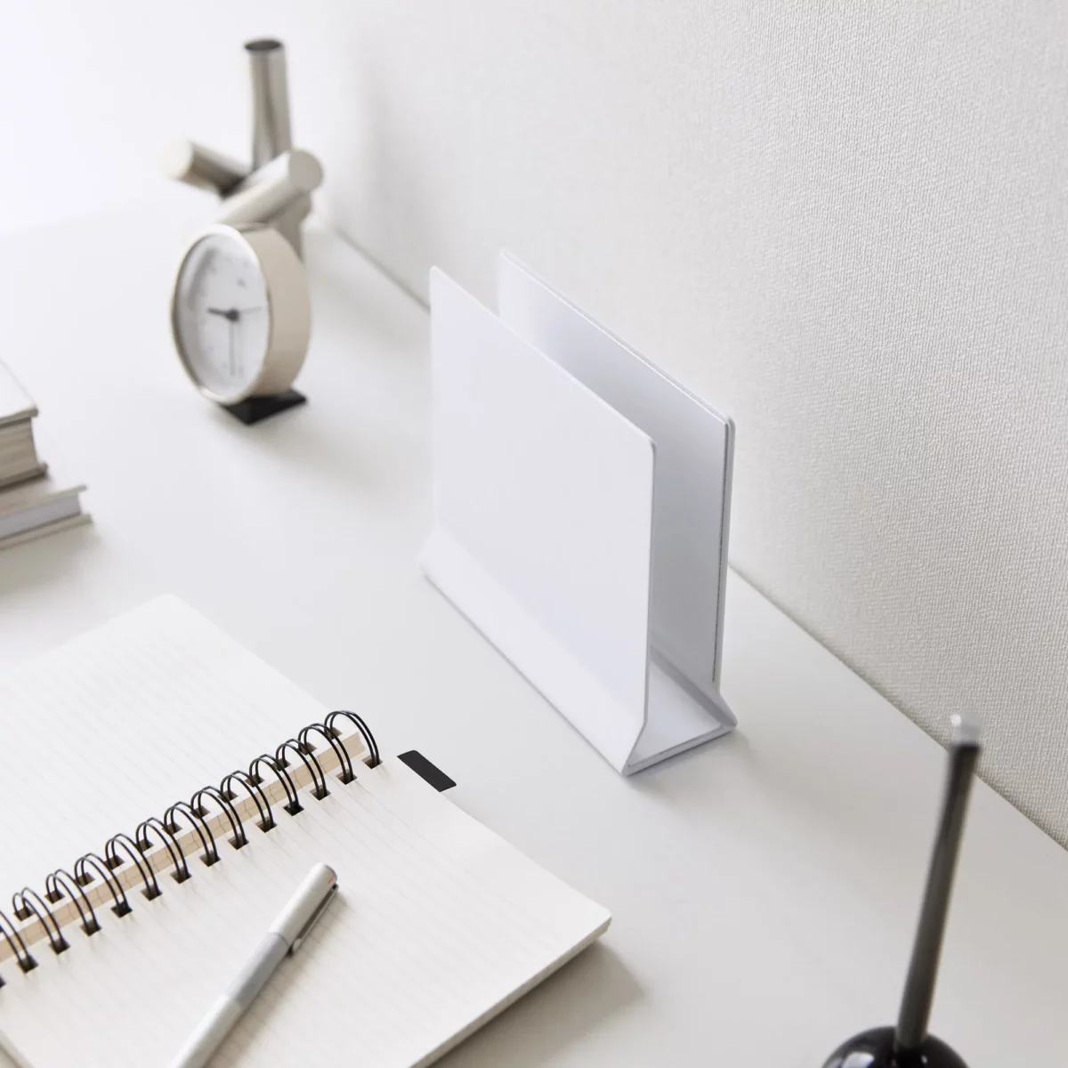 Support pour ordinateur portable Yamazaki TOWER vertical, blanc, posé à vide sur le bureau à côté du cahier
