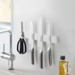 Yamazaki TOWER Magnetic Knife Rack in White, mounted on the kitchen wall with three knives and a pair of scissors