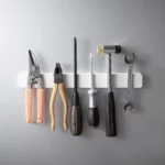 Yamazaki TOWER Magnetic Knife Rack in White, with pliers, screwdriver, and hammer on a gray wall