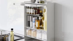 Yamazaki TOWER Gewürzregal mit drei Etagen auf einer weissen Küchenarbeitsfläche neben Schneidebrett und Gemüse