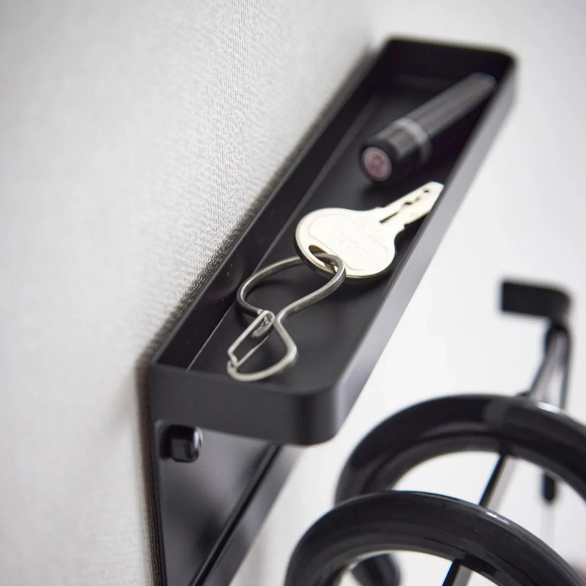 Yamazaki Schirmhalter SMART für die Wand in Schwarz, Nahaufnahme der Ablage mit Schlüssel und Taschenlampe