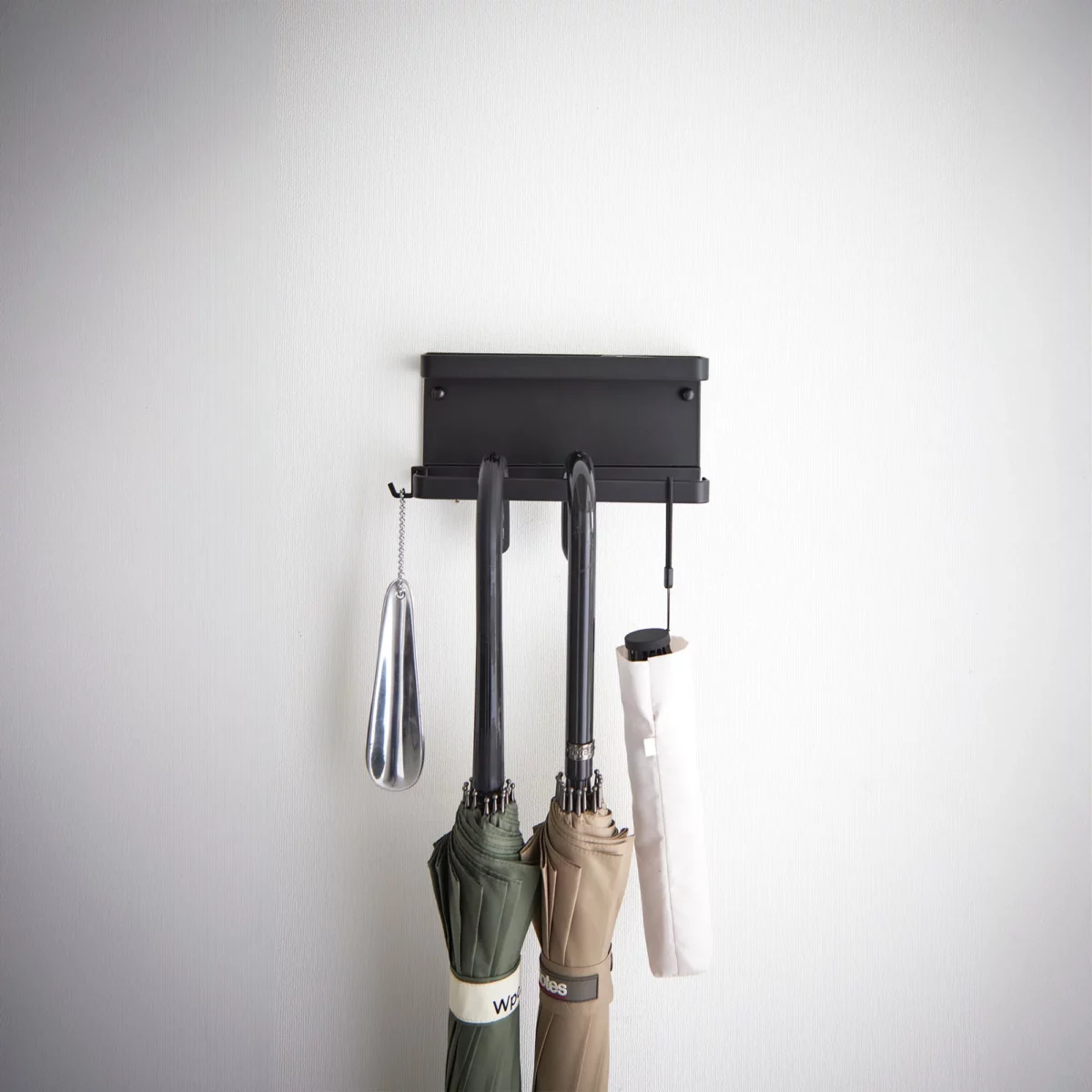 Yamazaki Schirmhalter SMART für die Wand in Schwarz, von vorne mit Schirmen und Schuhlöffel