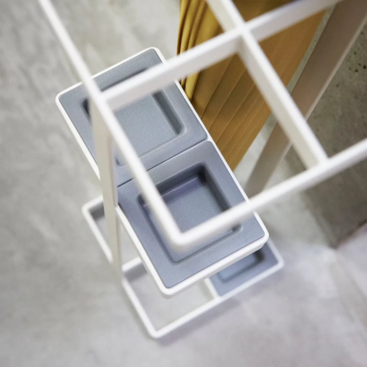 Yamazaki TOWER Narrow Umbrella Stand in White, close-up of the gray drip trays on two levels