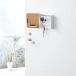 Yamazaki RIN Magnetic Key Box in White, placed open next to the door handle on the front door