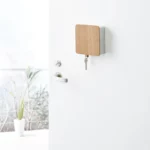 Yamazaki RIN Magnetic Key Box in White, locked on the front door, with one key hanging from the bottom