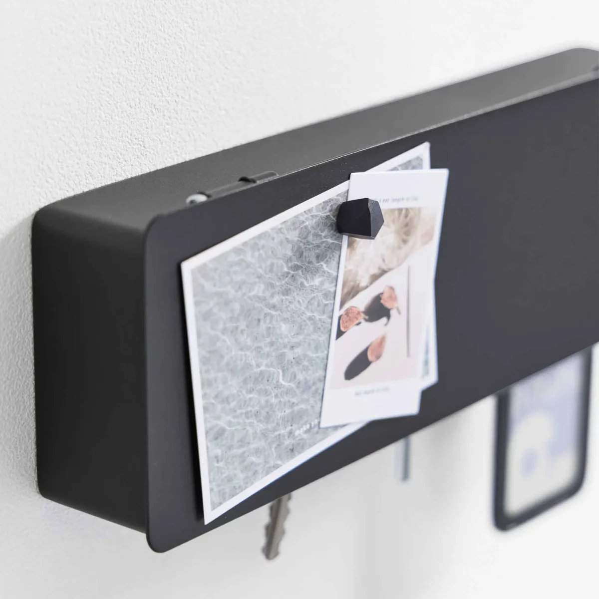 Yamazaki TOWER Wide Key Box in Black, with a postcard and magnet on the lid; keys protrude from the bottom