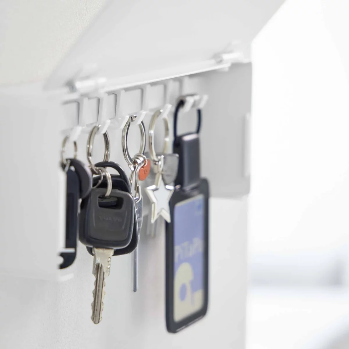 Yamazaki TOWER Wide Key Cabinet in White, close-up of key bundles on the hooks under the lid