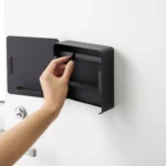 Yamazaki Schlüsselkasten TOWER magnetisch in Schwarz, Hand versetzt einen Haken im geöffneten Kasten