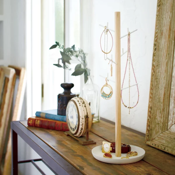 Yamazaki TOSCA Jewelry Tree with a white bowl, on the wooden console next to books and a clock