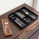 Yamazaki RIN 3-Tier Slim Jewelry Box in Black, with compartments lined with glasses, pearls, and earrings