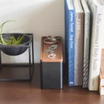 Yamazaki RIN 3-Tier Narrow Jewelry Box in Black, tucked between a plant and some books on the dresser
