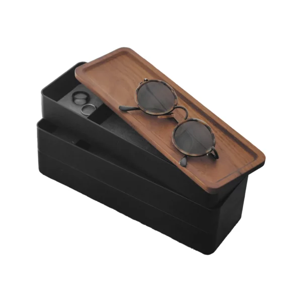 Boîte à bijoux Yamazaki RIN à 3 étages, modèle étroit, de couleur noire, avec des lunettes de soleil posées sur le couvercle en bois décalé, fond blanc