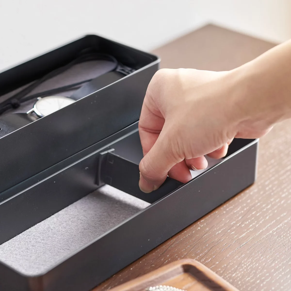 Yamazaki RIN 3-Tier Narrow Jewelry Box in Black; Hand places a divider in a compartment