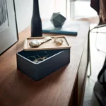Yamazaki Schmuckbox RIN mit Holzdeckel in Schwarz, auf der Kommode, Deckel schräg, Brillen im Innern