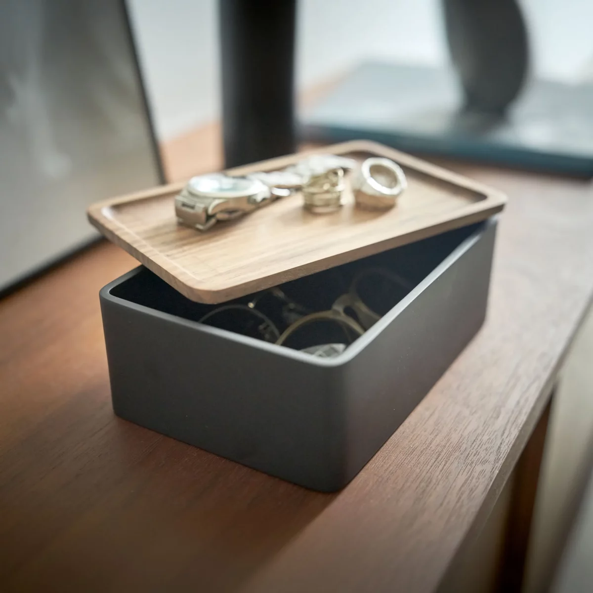 Yamazaki Schmuckbox RIN mit Holzdeckel in Schwarz, schräg von vorne mit Uhr und Ringen auf dem Deckel