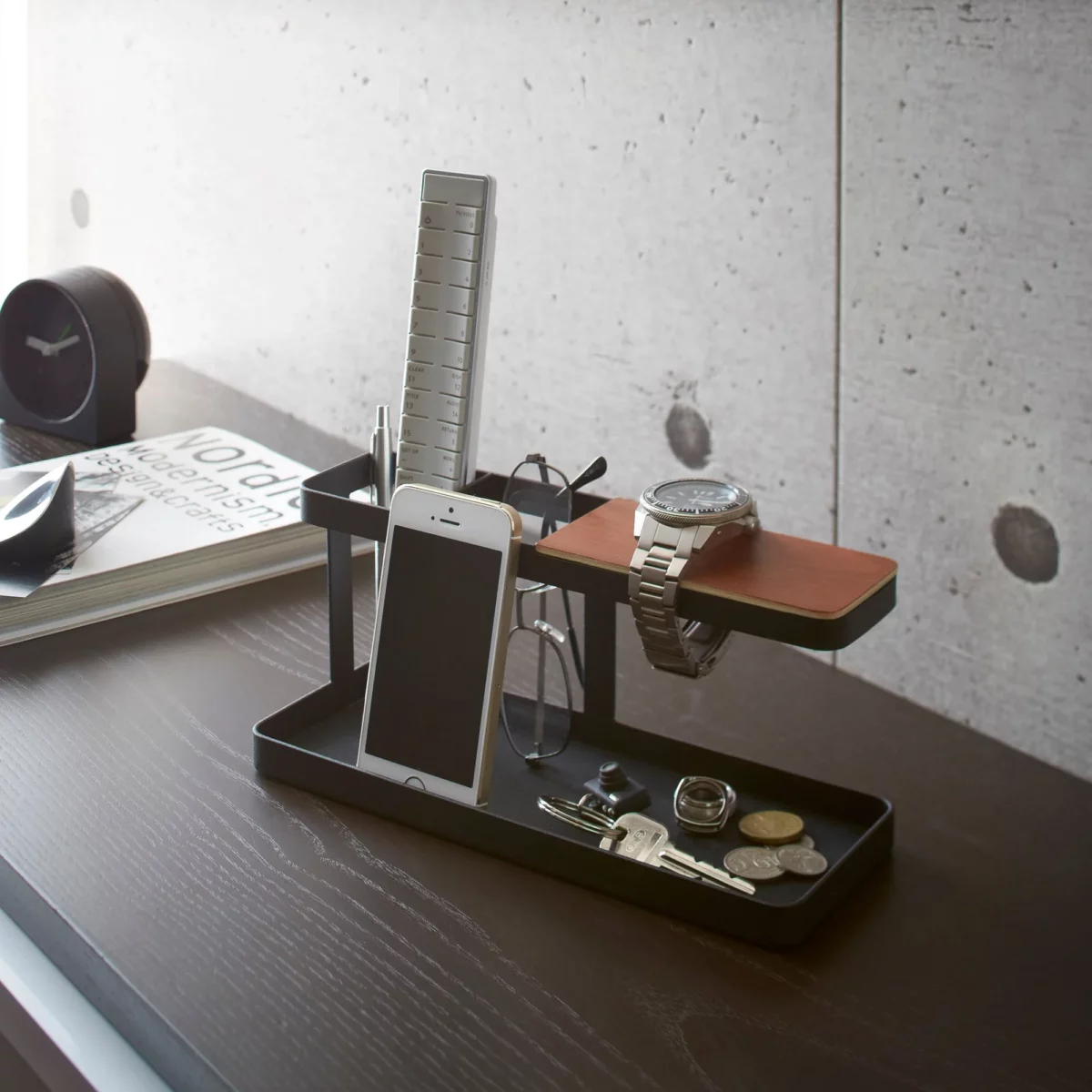 Yamazaki Schreibtisch-Organizer TOWER in Schwarz, auf dem dunklen Schreibtisch vor Betonwand