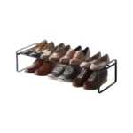 Étagère à chaussures Yamazaki FRAME extensible, noire, présentant des chaussures sur deux niveaux, en découpe sur fond blanc